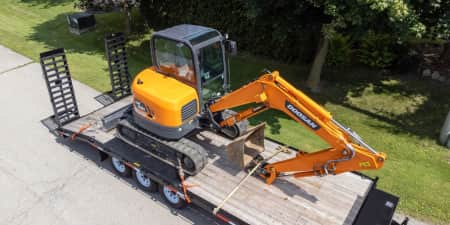 Doosan mini excavator being hauled on a trailer